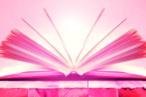 Open book on wooden table.